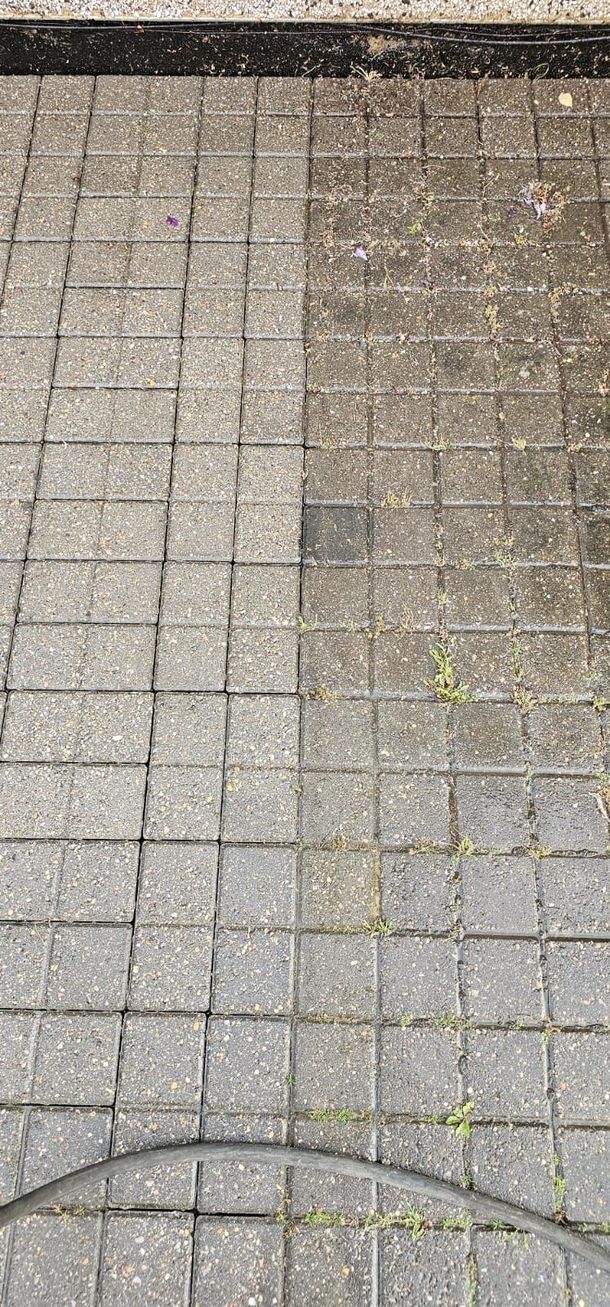 Before and after view of block paving, showing half the surface cleaned and the other half still covered in moss and dirt